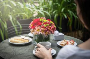 a table with a vase of flowers and a cup of coffee at Deco Collection in Buenos Aires +51 photos