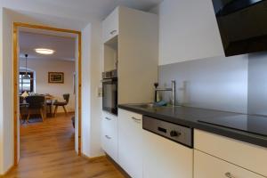 a kitchen with white cabinets and a dining room at Traunreiter Apartment in Bad Goisern +16 photos