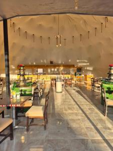 a restaurant with tables and chairs and a large ceiling at Sofia Bubble Luxury Camp in Disah