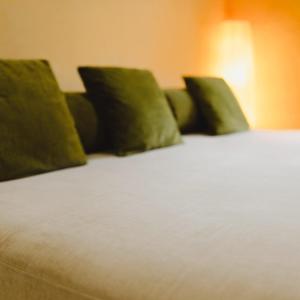 a bed with green pillows on top of it at Casa vacanze "INCANTO DEL LAGO" in Corna +33 photos
