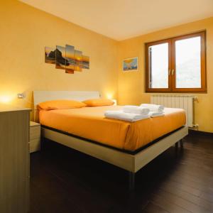 a bedroom with a bed with two towels on it at Casa vacanze "INCANTO DEL LAGO" in Corna