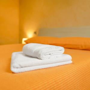 two towels are stacked on top of a bed at Casa vacanze "INCANTO DEL LAGO" in Corna