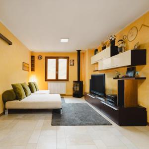 a living room with a couch and a tv at Casa vacanze "INCANTO DEL LAGO" in Corna