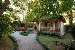 a house with a gravel path in front of it at Green Mansions Jungle Resort in Sauraha