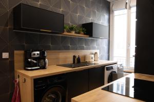 a kitchen with a stove and a sink and a dishwasher at Au bonheur de Troyes in Troyes