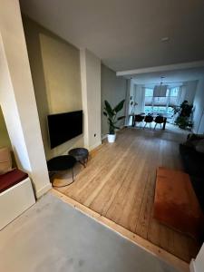 an empty living room with a flat screen tv at Maastricht House Anne in Maastricht
