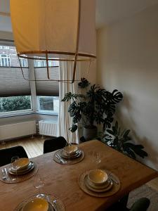 a wooden table with plates and wine glasses on it at Maastricht House Anne in Maastricht +20 photos