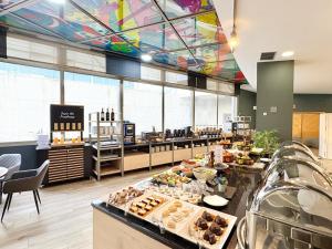 a restaurant with a buffet with a colorful ceiling at Eurohotel Barcelona Granvia Fira in Hospitalet de Llobregat