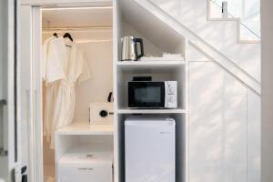 a room with a staircase with a microwave and a tv at Sela Lanta in Ko Lanta