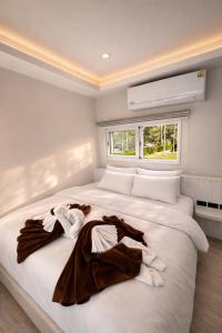 a bedroom with a large white bed with towels on it at Sela Lanta in Ko Lanta