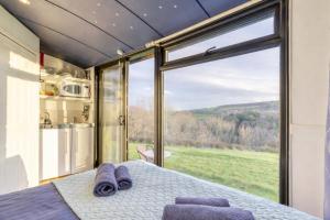 a bedroom with a bed and a large window at Shepherds Hut in Staithes