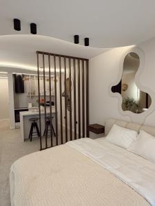 a bedroom with a large white bed and a kitchen at Mediteran Line Apartman 1 in Sombor +12 photos