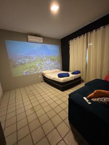 a room with two beds and a large screen at Garden Room Comfort in Garanhuns
