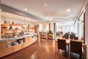 a restaurant with a counter and a table and chairs at Luna Inn Stuttgart City in Stuttgart