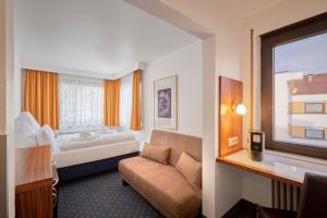 a hotel room with a couch and a bed at Luna Inn Stuttgart City in Stuttgart