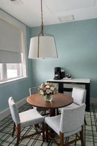 a dining room table with chairs and a vase of flowers at The Laurel Hotel in Danville