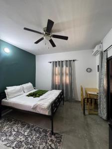 a bedroom with a bed and a ceiling fan at Hôtel La Maison Blanche in Saint-Louis