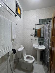 a bathroom with a toilet and a sink at Hôtel La Maison Blanche in Saint-Louis +31 photos