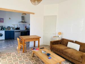 a living room with a couch and a table at Gîte Mas La Bohème Piscine Parking Privé L'Isle-Sur-La-Sorgue in L'Isle-sur-la-Sorgue