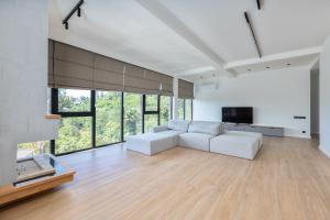 a living room with a white couch and a tv at Gantiadi Holiday - Pool and Houses in Batumi