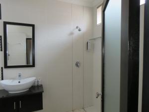 a white bathroom with a sink and a mirror at Jedidja Bed and Breakfast in Bloemfontein +110 photos