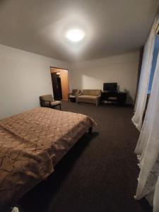 a bedroom with a bed and a couch and a desk at Motel Poltava in Poltava