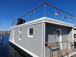 a tiny house on a boat in the water at Hausboot Hecht mit Dachterrasse in Schleswig in Schleswig