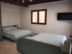 a bedroom with two beds and a flat screen tv at B&B Occhio di Adone in Monzuno +8 photos