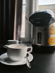a coffee cup on a plate next to a toaster at TM Room For Rent in Pattaya