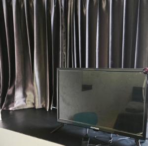 a television sitting on a table in front of a window at TM Room For Rent in Pattaya +7 photos