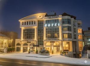 a hotel building with a sign on it at night at HighLand suites in Aley