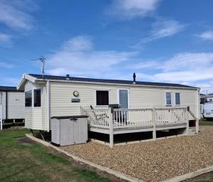 a white mobile home with a large deck at Beachside Heacham in Heacham