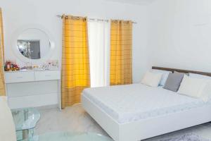 a bedroom with a white bed and a mirror at Hospedaria Santo António 2 in Praia Baixo