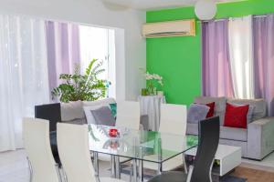 a dining room with a glass table and white chairs at Hospedaria Santo António 2 in Praia Baixo +20 photos