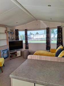 a living room with two beds and a flat screen tv at Beachside Heacham in Heacham