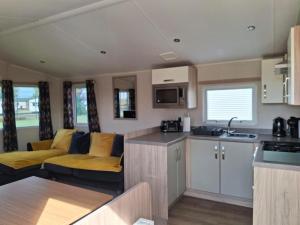 a caravan kitchen and living room with a couch at Beachside Heacham in Heacham