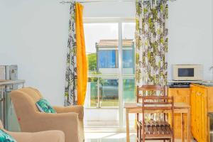 a living room with a table and chairs and a window at Hospedaria Santo António 2 in Praia Baixo