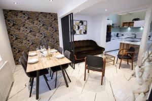 a dining room and living room with a table and chairs at Le Speakeasy - Maison avec billard in Auxerre