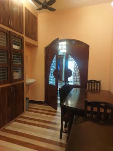 a dining room with a table and chairs and a door at Unique Stays in Pondicherry +2 photos