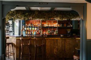 a bar with three bar stools in a room at Port Gaverne Hotel in Port Isaac +44 photos