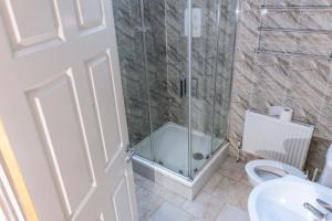 a bathroom with a glass shower with a toilet at Hacketts Bar And Accommodation in Kilkenny