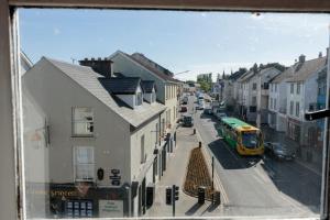 a view from a window of a city street with a bus at Hacketts Bar And Accommodation in Kilkenny +3 photos