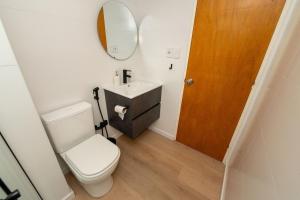 a bathroom with a toilet and a sink and a mirror at Monoambiente amplio , moderno y super completo in Montevideo +14 photos