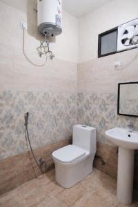 a bathroom with a toilet and a sink at Hotel V N Ganga in Rishīkesh +39 photos