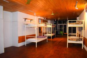 a room with four bunk beds in it with a wooden ceiling at Hotel V N Ganga in Rishīkesh