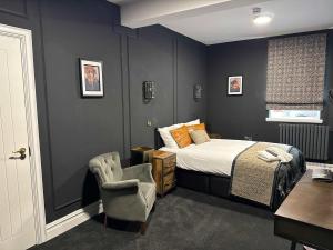 a bedroom with a bed and a chair at The Royal Keep Hotel in Dudley in Dudley
