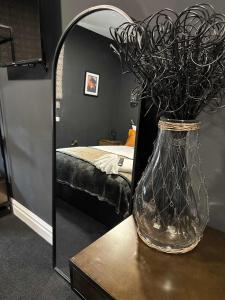a vase on a table in front of a mirror at The Royal Keep Hotel in Dudley in Dudley +113 photos