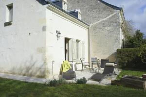 a patio with chairs and a table next to a building at L'Abeille bleue in Cheillé
