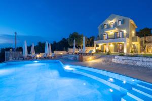 a villa with a swimming pool in front of a house at Hellosummer Boutique suites,near fiscardo! in Andipáta Erísou