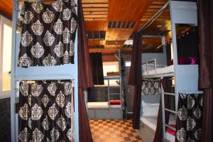 two bunk beds with curtains in a room at Hotel V N Ganga in Rishīkesh